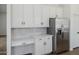 Kitchen with stainless steel refrigerator, white cabinets, quartz countertops and backsplash, and under cabinet lighting at 2994 E Mahogany Pl, Chandler, AZ 85249