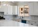 Bright kitchen features white cabinets, marble countertops and backsplash, and a view to the outside at 2994 E Mahogany Pl, Chandler, AZ 85249