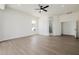 Open living room featuring light hardwood floors, white walls, a ceiling fan, and an arched doorway at 2994 E Mahogany Pl, Chandler, AZ 85249