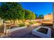 Beautifully landscaped backyard, featuring a deck and manicured desert landscaping at 3133 E Claire Dr, Phoenix, AZ 85032