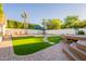 Inviting backyard featuring lush landscaping, a sparkling pool, and a cozy seating area at 3133 E Claire Dr, Phoenix, AZ 85032