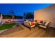 Beautiful backyard at dusk, showcasing a pool, outdoor seating, a fire pit, and a spacious wooden deck at 3133 E Claire Dr, Phoenix, AZ 85032