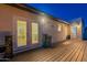 Outdoor patio with a wooden deck, french doors, and charming decorative accents under evening lights at 3133 E Claire Dr, Phoenix, AZ 85032