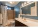 Bathroom with a tiled shower-tub combo and dark vanity at 3133 E Claire Dr, Phoenix, AZ 85032