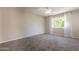 Spacious carpeted bedroom with a ceiling fan and natural light from a window at 3133 E Claire Dr, Phoenix, AZ 85032