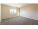 Neutral bedroom featuring neutral carpet, a ceiling fan, and a large window at 3133 E Claire Dr, Phoenix, AZ 85032