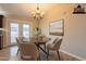 Staged dining area with round table, four chairs, and artwork, filled with natural light at 3133 E Claire Dr, Phoenix, AZ 85032