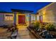 Inviting home entrance with a covered pergola, decorative red doors, and lush desert landscaping at 3133 E Claire Dr, Phoenix, AZ 85032