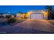 Charming single-story home featuring a wide driveway, well-lit facade, and desert landscaping, perfect for curb appeal at 3133 E Claire Dr, Phoenix, AZ 85032