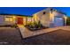 Home featuring desert landscaping, warm exterior lighting, and a welcoming front entrance at 3133 E Claire Dr, Phoenix, AZ 85032
