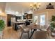 Virtually staged kitchen with dark wood cabinets, island with seating, and dining area with a round table at 3133 E Claire Dr, Phoenix, AZ 85032