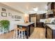 Stylish kitchen with dark wood cabinets, granite island, and open layout into dining area at 3133 E Claire Dr, Phoenix, AZ 85032