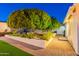 Landscaped backyard with pavers, lush trees, and manicured garden beds at 3133 E Claire Dr, Phoenix, AZ 85032