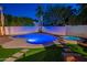 Stunning backyard pool and spa illuminated at twilight, creating a serene oasis at 3133 E Claire Dr, Phoenix, AZ 85032