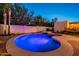 A captivating view of the sparkling pool and spa, enhanced by lush landscaping and serene lighting at 3133 E Claire Dr, Phoenix, AZ 85032