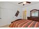 Comfortable bedroom with a ceiling fan, a bed with a decorative comforter, closet, and a dresser at 31716 N Poncho Ln, San Tan Valley, AZ 85143