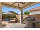 Covered patio featuring a built-in grill, dining set, and landscaped backyard at 31716 N Poncho Ln, San Tan Valley, AZ 85143