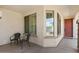Covered patio with neutral paint, two dark brown chairs, tan flooring, and three large windows at 31716 N Poncho Ln, San Tan Valley, AZ 85143