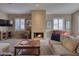 Cozy living room with a stone fireplace, plush seating, and plenty of natural light through plantation shutters at 3212 E Desert Cove Ave, Phoenix, AZ 85028