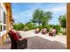 Outdoor patio area with brick pavers, mature landscaping and comfortable red striped patio furniture at 3358 W Sandra Ter, Phoenix, AZ 85053