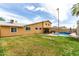 Lush backyard featuring a pool, covered patio, mature trees, and green lawn, perfect for relaxation and recreation at 3358 W Sandra Ter, Phoenix, AZ 85053