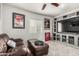 Relaxing living area with a leather couch, ottomans, TV, and built-in shelving for entertainment and storage at 3358 W Sandra Ter, Phoenix, AZ 85053