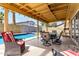 Relaxing covered patio with outdoor seating, ideal for lounging by the pool in a serene backyard setting at 3358 W Sandra Ter, Phoenix, AZ 85053