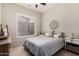 Cozy bedroom featuring a queen size bed with soft color bedding, a ceiling fan, and windows for natural light at 3460 N Stone Gully St, Mesa, AZ 85207