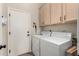 Functional laundry room with a washer, dryer, cabinetry for storage, and access door for convenience at 3460 N Stone Gully St, Mesa, AZ 85207