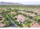 Expansive aerial view of a meticulously maintained community with green spaces, golf course, and mountain scenery at 3521 N Hooper St, Buckeye, AZ 85396