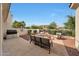 Backyard featuring a seating area with a fire pit, built-in grill, and lush landscaping at 3521 N Hooper St, Buckeye, AZ 85396