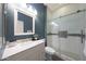 Well-lit bathroom showcasing a white vanity, a large mirror, toilet, and a glass enclosed shower at 3521 N Hooper St, Buckeye, AZ 85396
