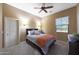 Bedroom featuring a queen bed, carpeted floors, neutral paint, ceiling fan, and a bright window at 3521 N Hooper St, Buckeye, AZ 85396