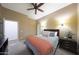 Bedroom featuring a queen bed, carpeted floors, neutral paint, ceiling fan, and a bright window at 3521 N Hooper St, Buckeye, AZ 85396