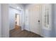 Bright entryway featuring wood floors, white trim, and a view into the hallway at 3521 N Hooper St, Buckeye, AZ 85396