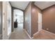 Hallway view with neutral tones leading to a bedroom with shuttered windows for natural light at 3521 N Hooper St, Buckeye, AZ 85396