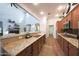 Kitchen with granite countertops overlooking a living area featuring a fireplace and vaulted ceilings at 3521 N Hooper St, Buckeye, AZ 85396