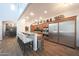 Open kitchen with stainless steel appliances, granite countertops, and a breakfast bar with upholstered seating at 3521 N Hooper St, Buckeye, AZ 85396