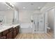 Bright bathroom with double vanity, soaking tub, glass shower, and tile flooring at 35746 N 32Nd Ln, Phoenix, AZ 85086