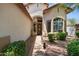 Inviting entryway with a wooden front door, lush landscaping, and a well-lit walkway at 35746 N 32Nd Ln, Phoenix, AZ 85086