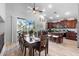 Open kitchen and dining area with dark wood cabinets, a center island, and sliding glass doors at 35746 N 32Nd Ln, Phoenix, AZ 85086