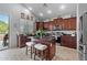 Modern kitchen with dark wood cabinets, granite countertops, a center island with seating, and stainless steel appliances at 35746 N 32Nd Ln, Phoenix, AZ 85086