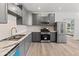Modern kitchen featuring gray cabinetry, stainless steel appliances, and elegant marble countertops at 3824 W Puget Ave, Phoenix, AZ 85051