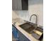 Close-up of a stainless steel kitchen sink with a modern faucet and marble countertops at 3824 W Puget Ave, Phoenix, AZ 85051