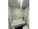 Bathroom shower with modern fixtures, white marble tiling and dark flooring at 3824 W Puget Ave, Phoenix, AZ 85051