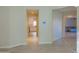 Hallway with tile flooring leads to a kitchen featuring white cabinets at 4187 N 298Th Ln, Buckeye, AZ 85396