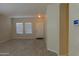 Bright living room with tile flooring, multiple windows, and an entry door at 4187 N 298Th Ln, Buckeye, AZ 85396