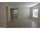 Open-plan living room showcasing neutral colors, tile flooring, and natural light from a large window at 4187 N 298Th Ln, Buckeye, AZ 85396