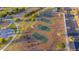 Aerial view showcasing the community's four well-maintained tennis courts with a playground, sand volleyball court, and parking lot nearby at 4187 N 298Th Ln, Buckeye, AZ 85396