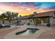 Resort-style backyard with a sparkling pool, spa, covered patio, and lush desert landscaping at 4329 W Electra Ln, Glendale, AZ 85310
